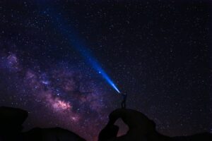 Man with headtorch gazing into starry sky