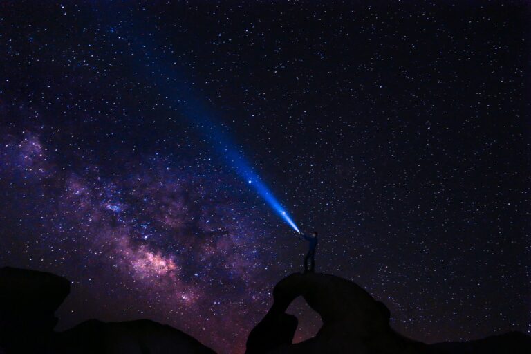 Man with headtorch gazing into starry sky